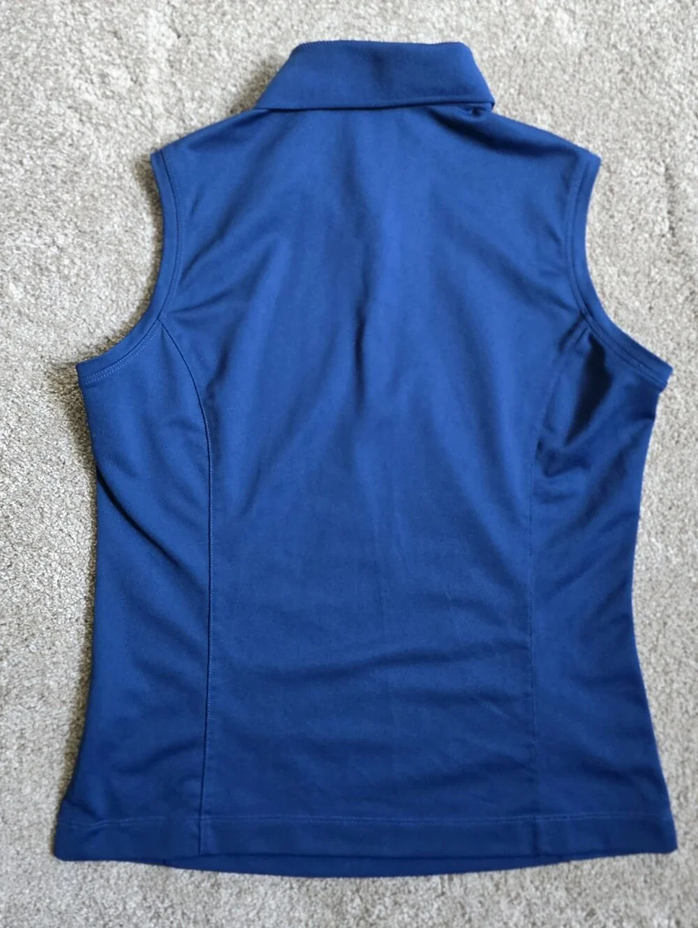 Royal blue sleeveless Nike Golf polo featuring a white-buttone